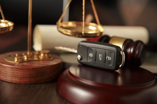 Car keys next to a judge's gavel in the office of a Boston DUI attorney